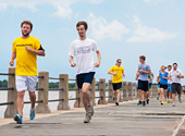 A Charleston Steeplechase Tour group runs along the boardwalk at White Point Gardens.
