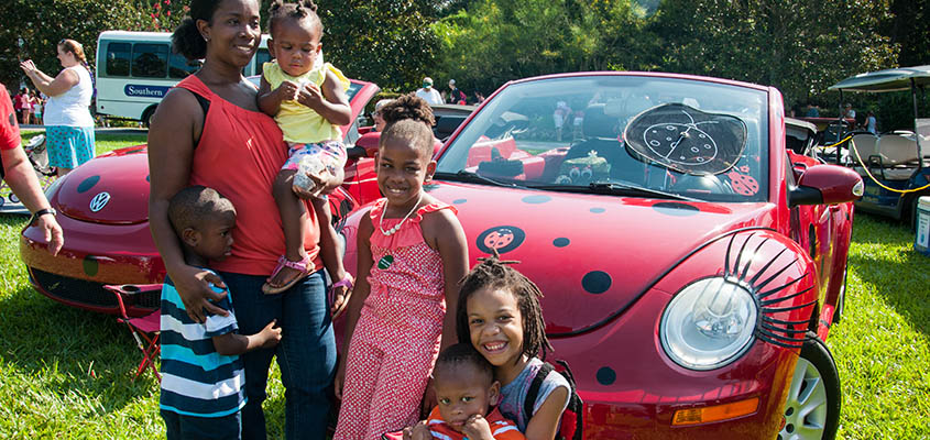 Guests pose in front of one of the VW bugs that delivers the ladybugs to the gardens. © 2016 Audra L. Gibson